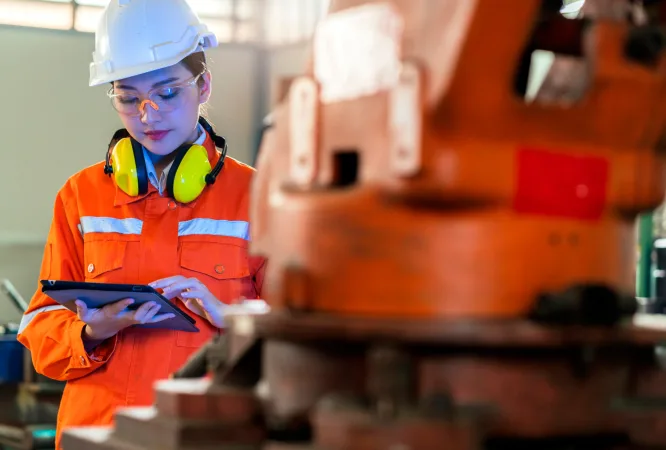 asian female engineer specialist with Measuring machine with a manipulator arm.Three-dimensional coordinate measurement. Check sizes. 3D check of the sizes of parts. CMM after machining process
